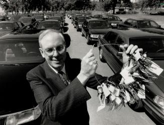 Ready to roll: Ford of Canada boss Kenneth Harrigan displays keys yesterday to 125 Lincoln and Sable cars Ford is providing to transport delegates at the Economic Summit