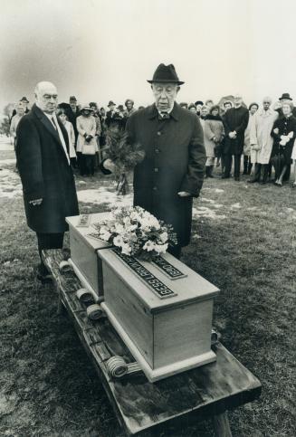 A. Y. Jackson, last surviving member of the original Group of Seven, Canada's most famous artists, places pine boughs on the caskets of Lawren Harris (...)