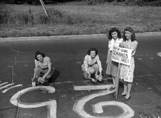 Westinghouse strike : workers painting sign on road