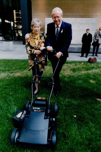 Communications Minister Karen Haslam and industry Minister Ed Philip pay a hands-on tribute to Black and Decker cordless power mower as money-making Canadian design
