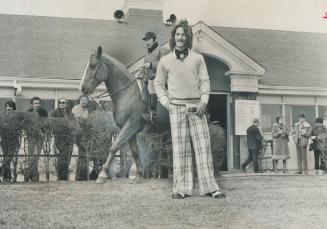 Sandy Hawley, North America's super star jockey photographed at Greenwood Raceway, looks great in off white and blue checked baggie pants with 2 1/2-i(...)
