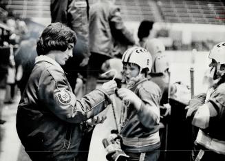 Sandy Hawley, North American champion jockey, offers water bottle to Gord Horricks of Wexford cub, which he sponsors, during Timmy Tyke grand champion(...)