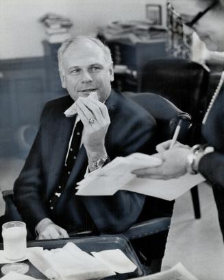 Paul Hellyer, Canada's minister of transport, finds that between federal business and his campaign travelling he often has time only to grab a ham san(...)