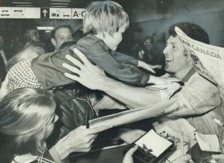 Welcoming her daddy home, 4-year-old Jill Henderson is handed over the heads of Team Canada fans into the arms of her father at Toronto International (...)