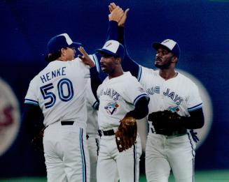 High fives: Blue Jays' Tom Henke accepts high fives from Devon White and Mark Whiten, right, after preserving last night's 4-3 win over Red Sox