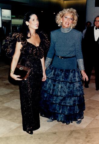 Stephanie Hill, above left, wears a deep brown private label gown with a deeply cut V-back, and wide ruffle detail at the back and shoulders. Her moth(...)