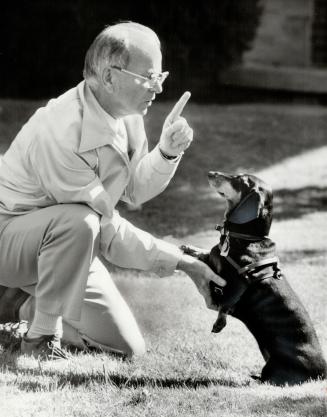 Harold Hilliard of Willowdale, a Star reporter, makes a point with his dachshund, Trudeau