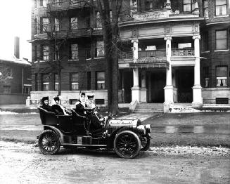 Four women in a car in front of Alexandra Palace, a residential hotel, University Avenue, south of College Street