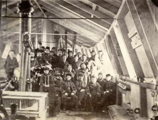 Image shows a crew posing for a photo inside the gunboat.