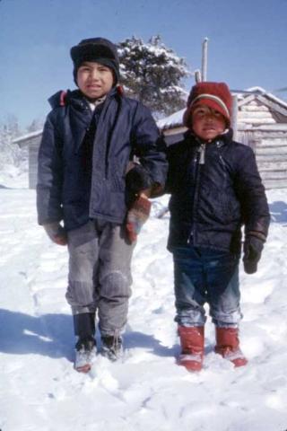 Two children standing in the snow