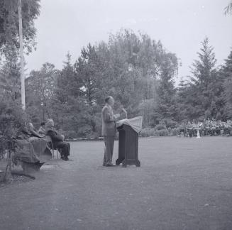 Image shows people gathered for an opening ceremony at the Edward Gardens.