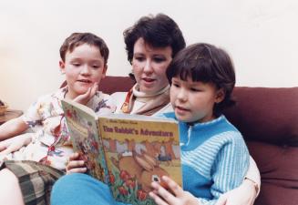 Single mother Deborah Williamson reads a story with her children, Jennifer, 10, and Christopher, 9