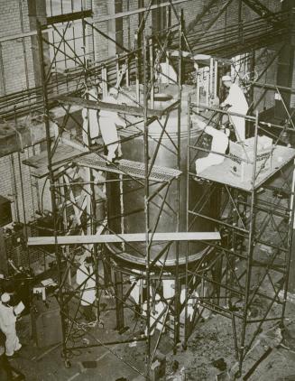 Work on new calandria à this picture shows men working on the new calandria which was placed in the reconstructed NRX reactor at the Chalk River, Ont., atomic plant which broke down a little more than a year ago.