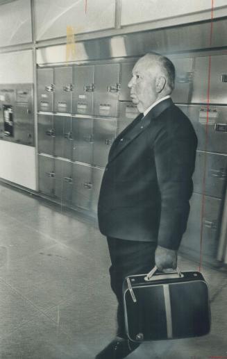 Alfred Hitchcock as imperturbable as usual, waits out weary delay after mechanical problems caused his plane to return to Toronto