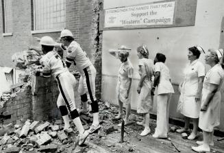 A touchdown. Argos Condredge Holloway: left: and John Foubert knock some bricks from the old Alexandra Wing to Toronto Western Hospital to mark the st(...)