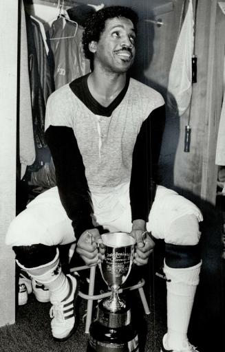 Fruits of victory: Argo QB Condredge Holloway holds the trophy awarded to the Eastern champions and he appears to like the feeling so much that only holding the Grey Cup would surpass it