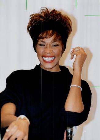 She flashed her dazzling smile Friday - and record company executives flashed statistics that said all that needed to be said about the popularity of Whitney Houston