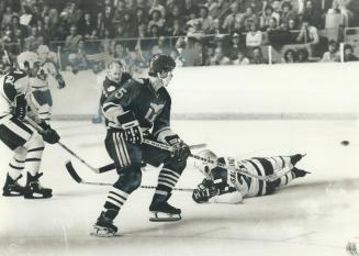 Howe blast. Mark Howe (5) of Hartford Whalers watches puck just shot by his father, Gordie (behind Mark) on its way into the Toronto net in National H(...)