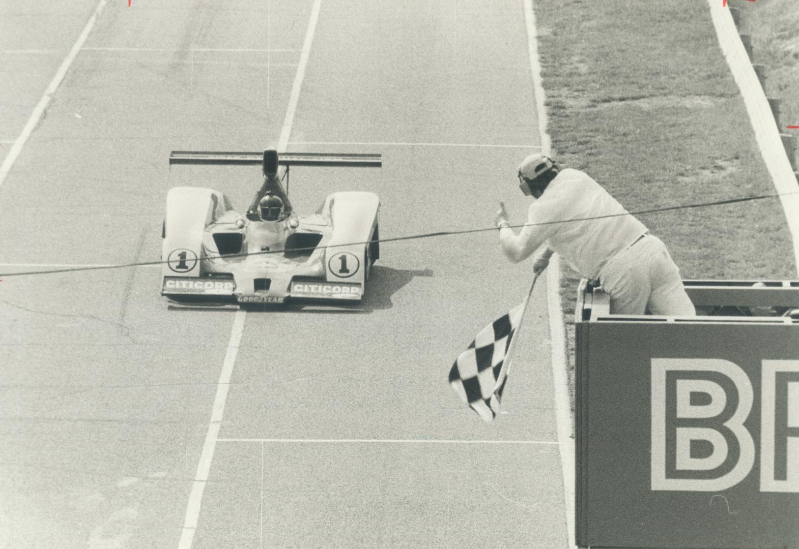 Jacky Ickx: driving No. 1 car, gets signal from official that he has won yesterday's Can-Am race at Mosport
