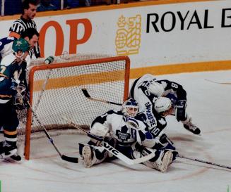 Falling down on the job: Leafs goaltender Peter Ing is crowded by teammates Vince Damphousse and Rob Ramage as he makes a save last night at the Gardens