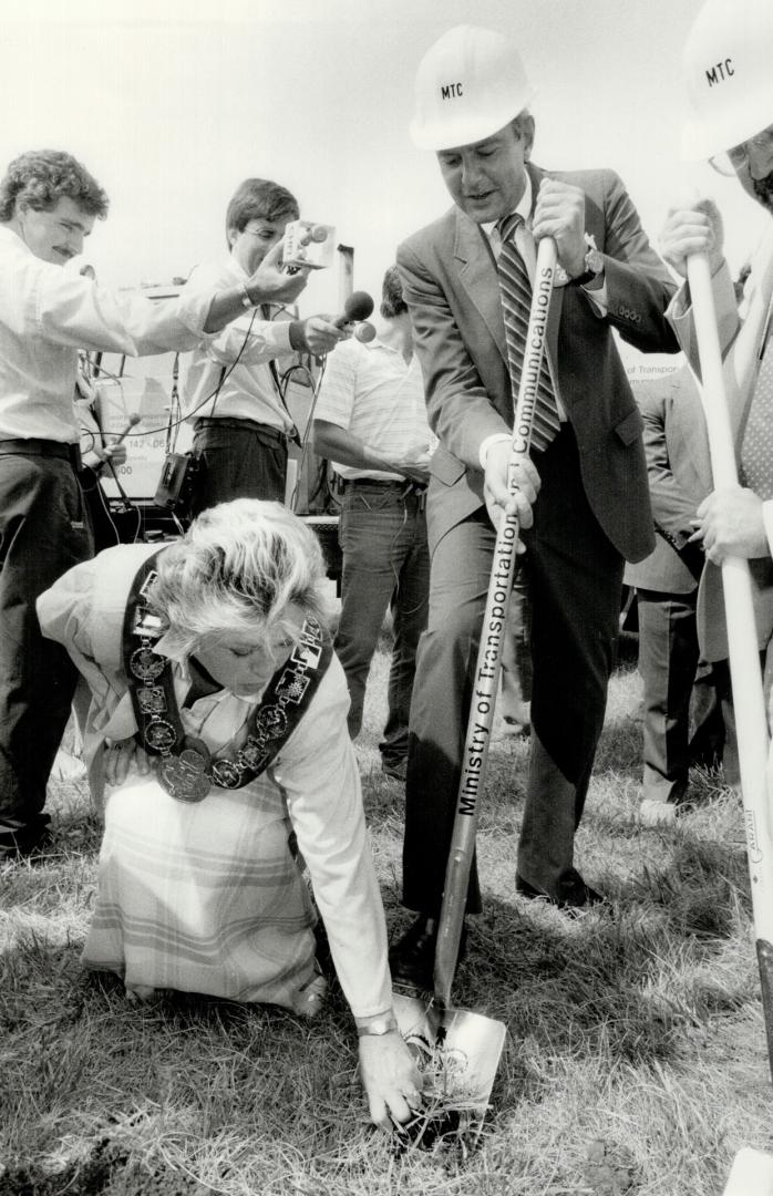 New highway: Vaughan Mayor Lorna Jackson grabs handful of grass yesterday as Premier David Peterson turns sod for new Highway 407: linking Highway 427 and Highway 400 north of Metro