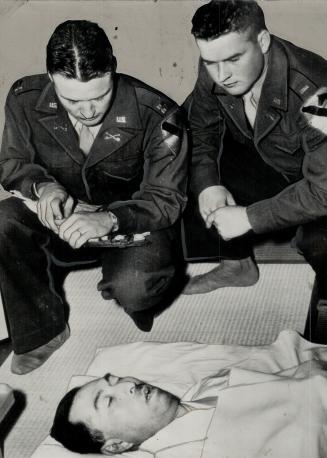 U.S. officers Capt. Charles Sewell, left and Lieut. Ivan Haselby, view Konoye's body in his home after discovery, of the suicide. He left a note telli(...)