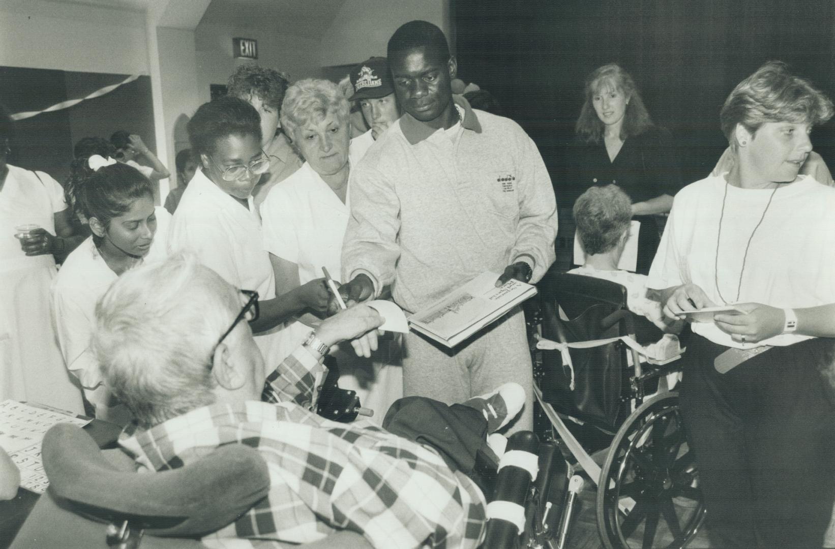 Patients at Queen Elizabeth Hospital eagerly seek Ben Johnson's autograph during his visit last week