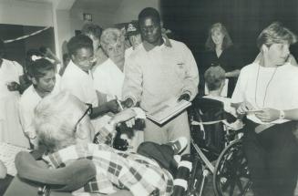 Patients at Queen Elizabeth Hospital eagerly seek Ben Johnson's autograph during his visit last week