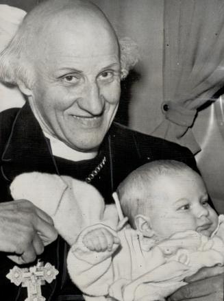 Hewlett Johnson, Dean of Canterbury, makes friends with a ng travel mate aboard his plane shortly before taking off from Bedford, Mass., for his return to London after visiting Toronto [Incomplete]