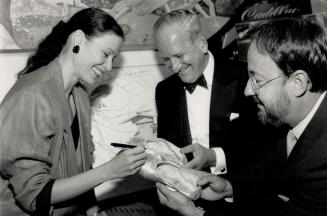 Signature celebration. National Ballet principal dancer Karen Kain autographs a pair of her slippers held by Harry Rosen, honorary chairman of the 50t(...)