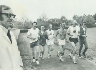 Image shows six men running while the doctor watches.