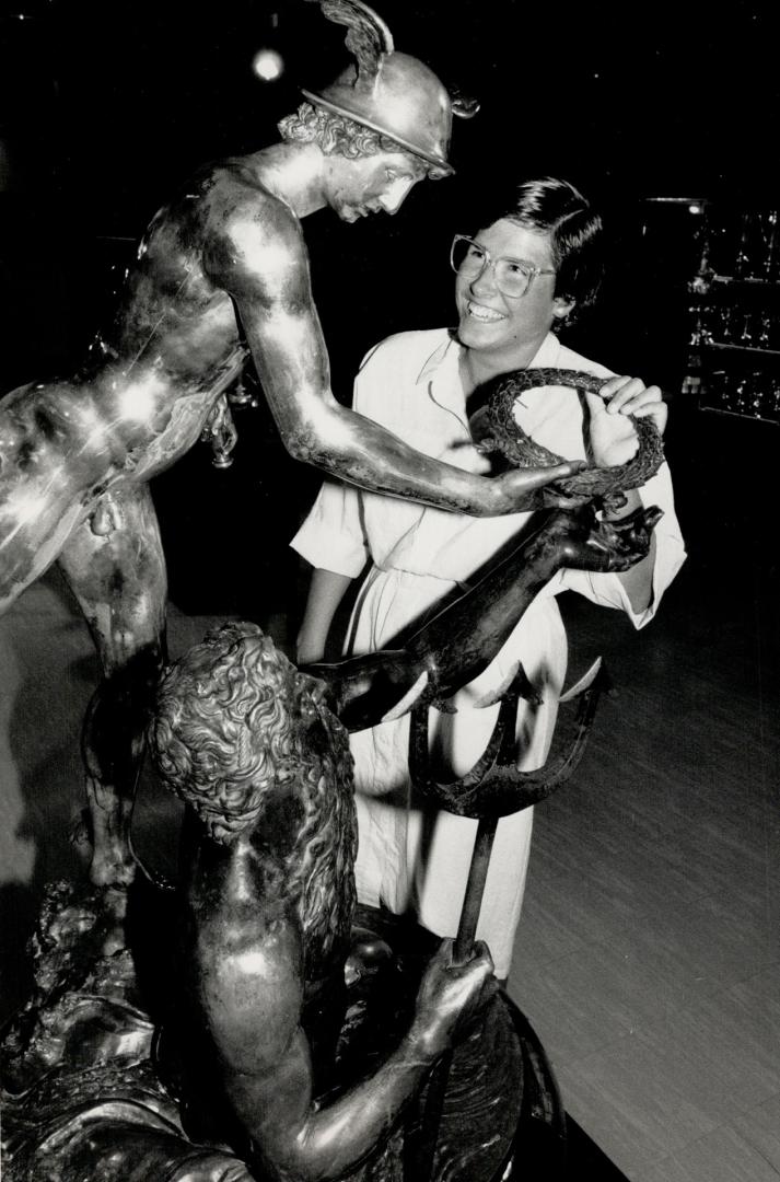 Marathon Prize. Swimmer Vicki Keith, who has conquered three Great Lakes, admires the Wrigley trophy, presented for marathon swimming in the 1920s, at Sports Hall of Fame