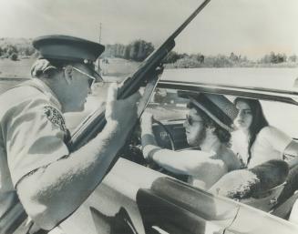 Attempting to recover a car stolen by a man believed to be escaper Donald Kelly, Tom O'Reilly and Maureen Belanger are stopped by a policeman at a roa(...)