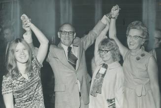 Arms raised in victory, Douglas Kennedy, 53, stands on platform at his campaign headquarters in Port Credit, with daughters Janet (left) and Pat, and (...)