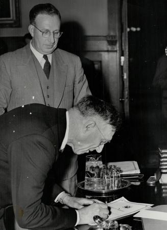Col. Kennedy signing Oath of office, Allan Stewart, clerk of the executive council