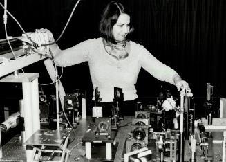 Laser research: Dr. Geraldine Kenney-Wallace, a leading authority in her field, adjusts a laser as she conducts an optoelectronic experiment at the La(...)