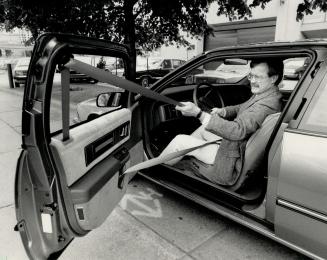 Columnist Jim Kenzie manhandles the 'passive restraint system' in the 1988 Buick Regal