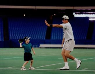 Argonauts backup quarterback Mike Kerrigan plays toss with his 5-year-old son, Michael Jr