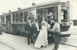 Brian Moonie, 24, and Diana Kilburn, 20, leave a 1920s streetcar Saturday after they were married while TTC operator Charles Price drove the car aroun(...)