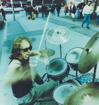 Ai-EE-AE-A-A-A-A-A-A-A-A!' THe drummer howls as he begins another agitated day on a downtown street corner