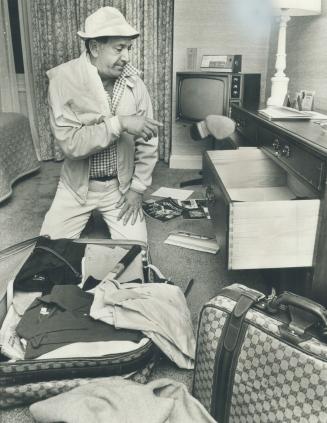 Playing his character to the hilt, Jack Klugman, the lovable slob, shows how he unpacks his suitcase in a Toronto hotel room. Klugman is here to play (...)