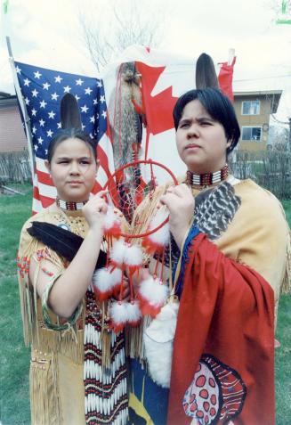 Two young indigenous people holding a dreamcatcher