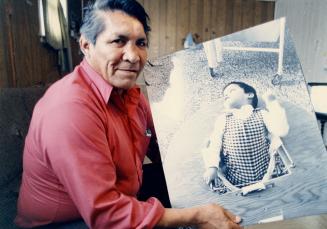 Marcel Pahpasay holds a picture of his son, born with birth defects believed to be the result of mercury poisoning