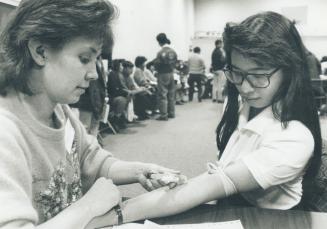 Nancy Cheng, 24, is assisted by nurse Charlene McInnis, left, as she gives a blood sample at a clinic at the Scarborough Chinese Baptist Church in the(...)