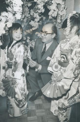 Spring in Toronto -- Japanese style, John Yaremko, Ontario minister of citizenship, kneels down to carefully adjust the obi worn by smiling 7-year-old(...)