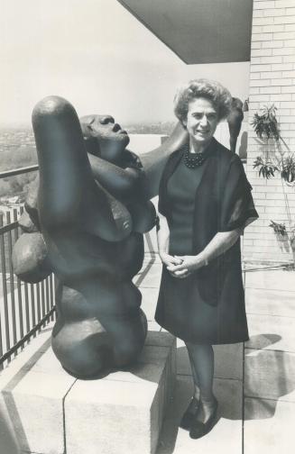Mrs. Samuel Zacks stands on veranda of her penthouse apartment with Jacques Lipchitz sculpture, Mother and Child. Despite her husband's death, she wil(...)