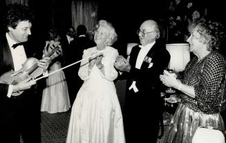 Above, left to right, being serenaded by violinist Tibor Olah are Mary and John Yaremko, a former solicitor-general of Canada, and Linda Camp