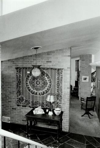 Above, colorful highlight of the front entrance hall is a Mennonite tapestry inherited from Yost's aunt