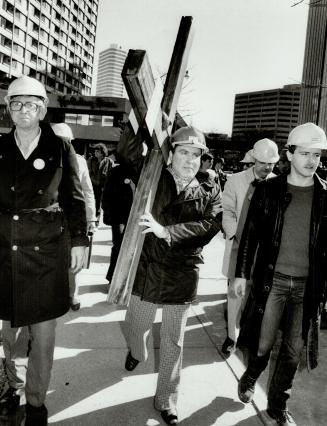 Heading to court: Surrounded by supporters in hard hats, publisher Ernst Zundel carries a cross with the words freedom of speech tacked to it before a judge sentenced him to 15 months
