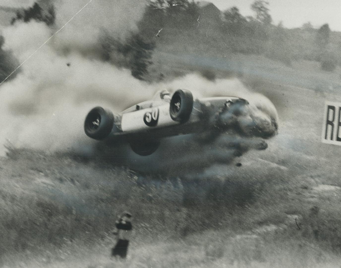 Away it goes. Racing car driven by Les Scott of Chicago, he's still in it, flies through the air in cloud of dust and smoke. The car spun off track, j(...)